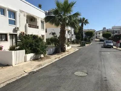 an empty street with a palm tree and buildings at Luxury Studio Ayia Napa Center in Ayia Napa
