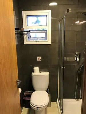 a bathroom with a toilet and a window and a shower at Luxury Studio Ayia Napa Center in Ayia Napa