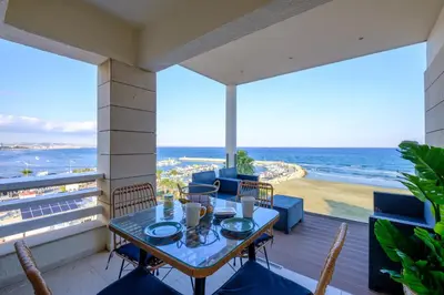 a table on a balcony with a view of the ocean at Lazuli Sea View Beachfront Ap 254 in Larnaka