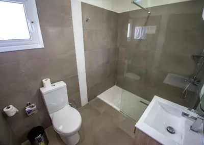 a bathroom with a toilet and a shower and a sink at Zodiac Hotel Apartments in Larnaka