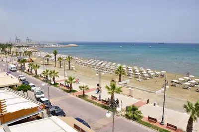 a view of a beach with umbrellas and the ocean at Zodiac Hotel Apartments in Larnaka