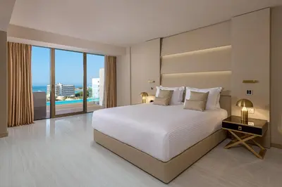 a bedroom with a white bed and a large window at Amarande (Adults Only) in Ayia Napa