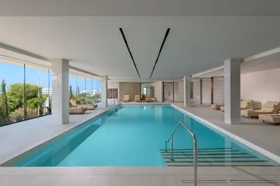 a large pool with blue water in a building at Amarande (Adults Only) in Ayia Napa