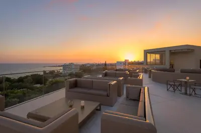 a rooftop patio with couches and a view of the ocean at Amarande (Adults Only) in Ayia Napa