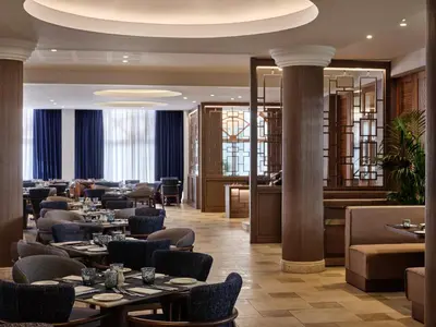 a restaurant with tables and chairs and columns at Atlantica Oasis Hotel in Limassol