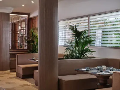 a restaurant with two tables and a pillar at Atlantica Oasis Hotel in Limassol