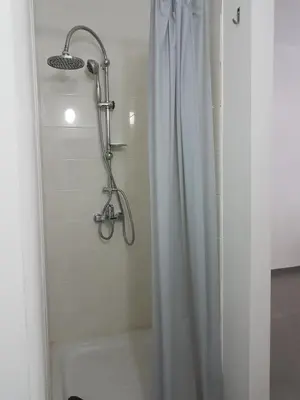 a shower with a white shower curtain in a bathroom at Julia's Residence in Nicosia