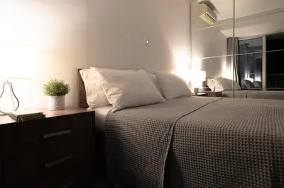 a bedroom with a bed and a table with a plant on it at Poseidon Apartment by Michalis in Ayia Napa