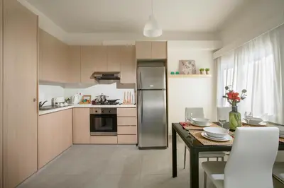 a kitchen with a table and a stainless steel refrigerator at Myrtiana Apartments in Nicosia