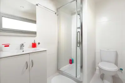 a white bathroom with a shower and a toilet at Myrtiana Apartments in Nicosia