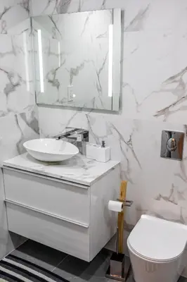 a white bathroom with a sink and a mirror at Bayview Terraces in Limassol