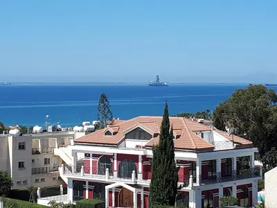 a large white house with a red roof and the ocean at Bayview Terraces in Limassol