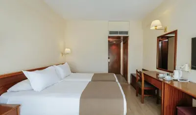 a hotel room with a bed and a desk at Odysseia Hotel Kapetanios in Limassol