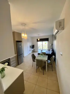 a kitchen and living room with a table and chairs at Mythical Sands Resort - Antonios in Paralimni