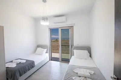two beds sitting in a room with a window at Villa Marylou in Protaras