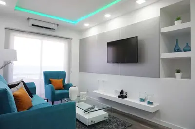 a living room with a blue couch and a tv at Lazuli Sea View Beachfront Ap 43 in Larnaka