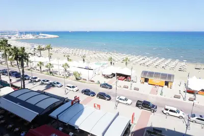 a beach with a lot of parked cars and umbrellas at Lazuli Sea View Beachfront Ap 43 in Larnaka