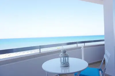 a table on a balcony with a view of the ocean at Lazuli Sea View Beachfront Ap 43 in Larnaka
