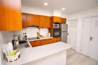 a kitchen with wooden cabinets and a white counter top at Lazuli Sea View Beachfront Ap 21 in Larnaka
