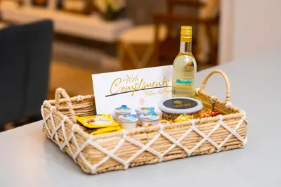 a basket with a bottle of wine and snacks at Lazuli Sea View Beachfront Ap 21 in Larnaka