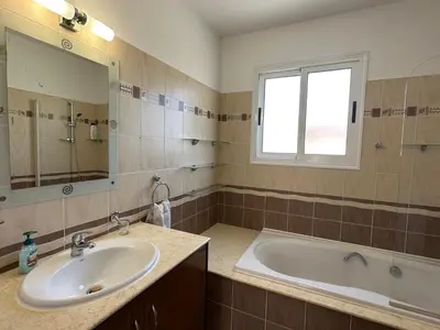 a bathroom with a sink and a tub and a window at Villa Andy-350 m from the beach in Larnaka