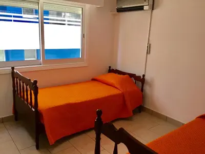 a bedroom with two beds and a window at Andreas Apartment in Limassol