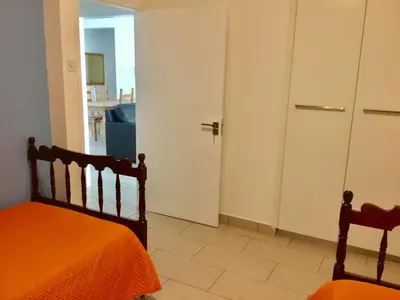 a bedroom with an orange bed and a door at Andreas Apartment in Limassol