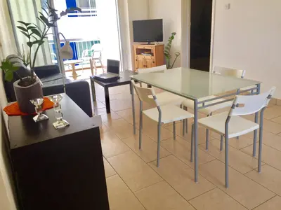 a dining table and chairs in a living room at Andreas Apartment in Limassol