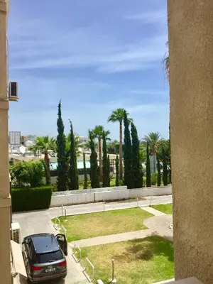 a car parked in a parking lot with palm trees at Andreas Apartment in Limassol