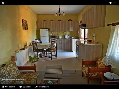 a kitchen and living room with a table and chairs at Amalia Panorama House in Zanaja