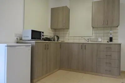 a kitchen with wooden cabinets and a microwave at River Apartments in Galata