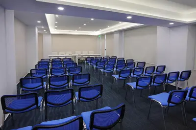 a conference room with blue chairs in a room at Nestor Hotel in Ayia Napa