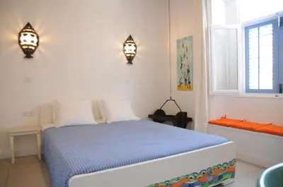 a bedroom with a bed and two lights on the wall at The Stable in Limassol