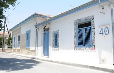 a white building with blue shutters on a street at The Stable in Limassol