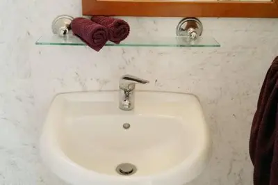 a bathroom with a white sink and a towel rack at Larnaka Beach House 3 in Larnaka