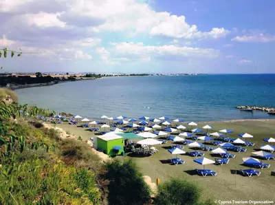 a bunch of umbrellas and chairs on a beach at Seaside Luxury Flat Pervolia in Pervolia