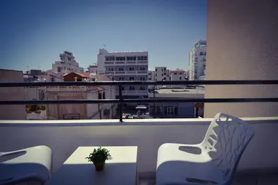 a balcony with a table and chairs and a view of a city at Krasas Beach Flats in Larnaka