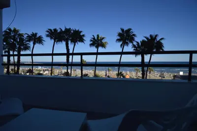 a view of the beach from a hotel balcony with palm trees at Krasas Beach Flats in Larnaka