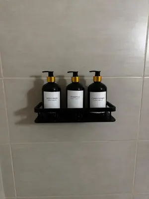 three bottles of soap on a shelf in a bathroom at Theodoros Apt. 408 in Protaras