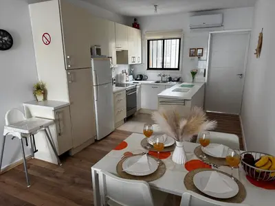 a kitchen with a table and chairs and a kitchen with white appliances at Theodoros Apt. 408 in Protaras