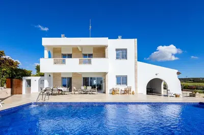 a villa with a swimming pool in front of a house at Villa Chrysta in Ayios Theodhoros