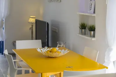 a yellow table with a bowl of fruit on it at Protaras Villa Loulla in Protaras