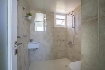 a bathroom with a shower and a sink at Larnaca Sunshore Beachfront Suite in Voroklini