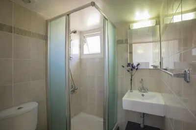a bathroom with a shower and a sink and a toilet at Larnaca Sunshore Beachfront Suite in Voroklini