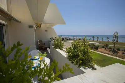 a balcony with a table and a view of the ocean at Larnaca Sunshore Beachfront Suite in Voroklini