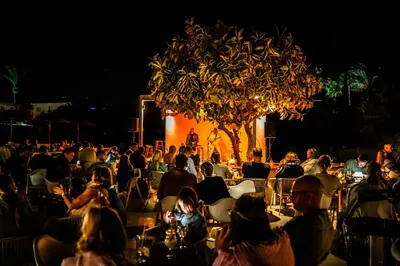 a crowd of people sitting in chairs in front of a stage at Malama Beach Holiday Village in Protaras