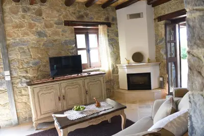 a living room with a tv on a stone wall at Spiti tis Irinis in Pedoulas