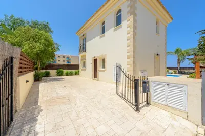 a large white house with a gate and a driveway at Villa Irina in Paralimni