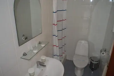 a bathroom with a toilet and a sink and a mirror at Lordos Hotel Apts Limassol in Limassol