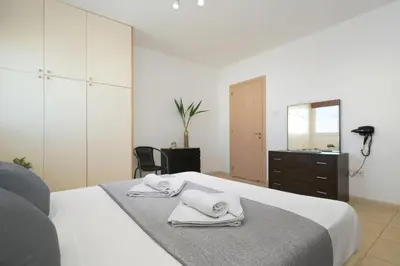 a bedroom with a white bed with towels on it at Neraida - 2Bed Apart walk to Kalamies Beach in Protaras